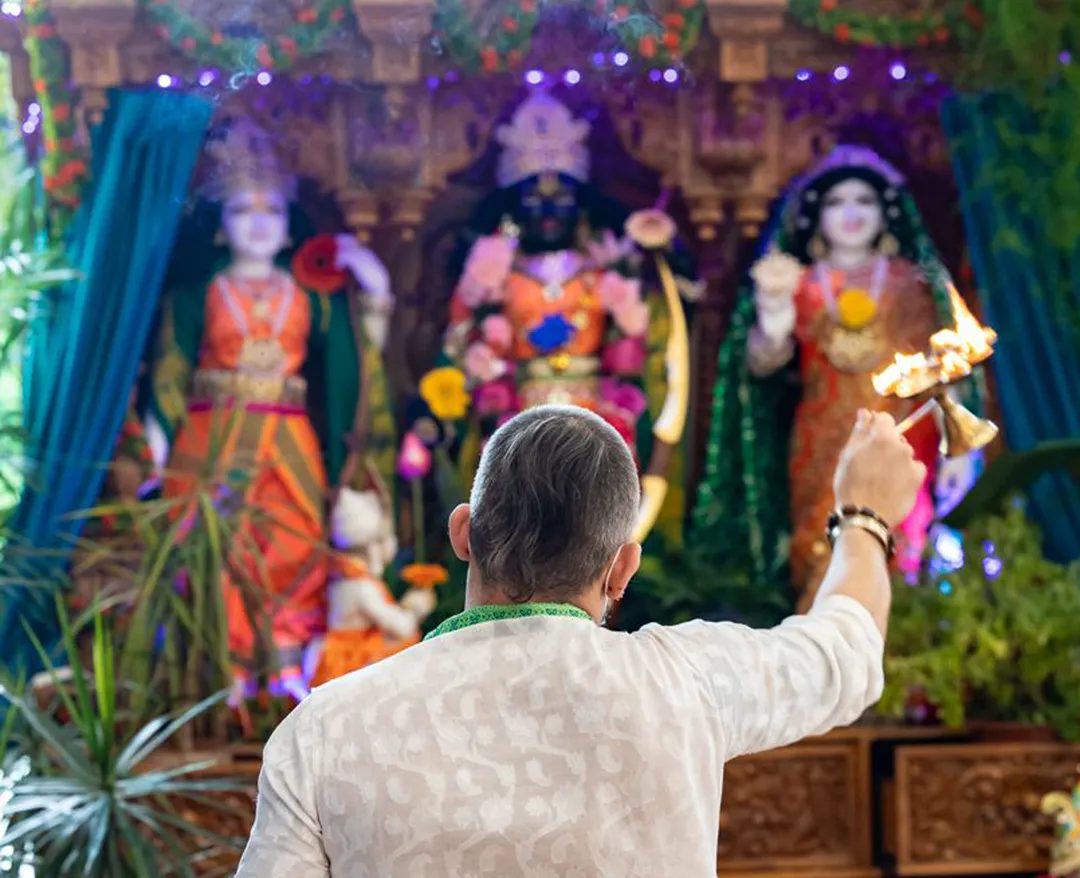 A priest performing arati before the deities