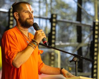 A Swami giving a talk outdoors