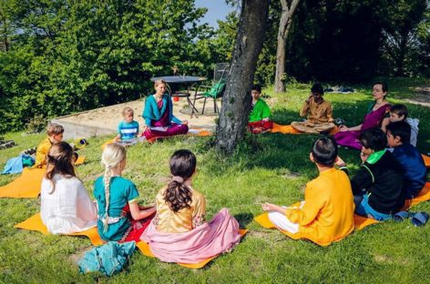 Children sitting together outdoors under the trees