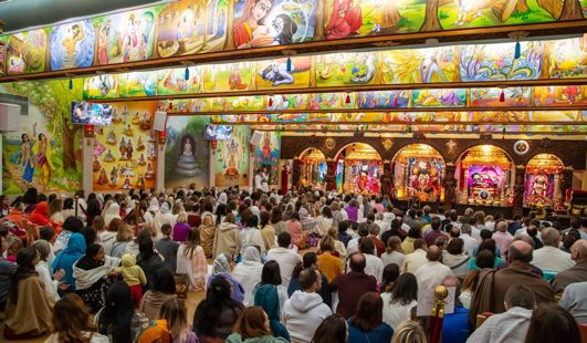 The temple hall filled with devotees during a celebration