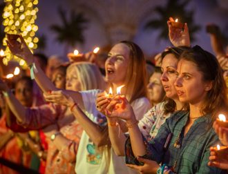 Devotees holding candles during an evening ceremony