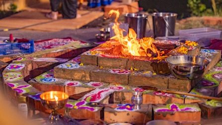 A fire ceremony surrounded by rangoli and flowers