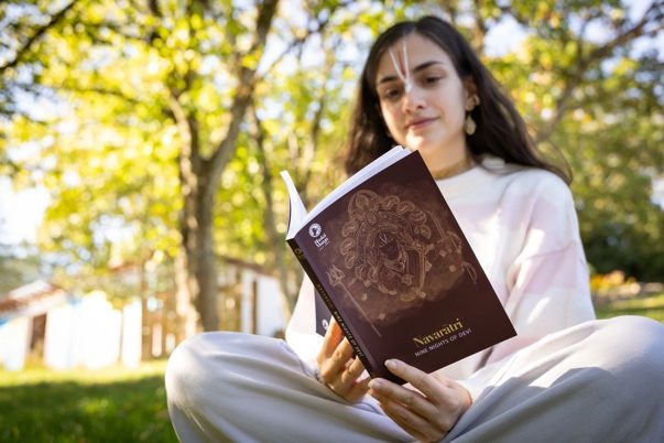 A scholarship holder studying a book in the garden